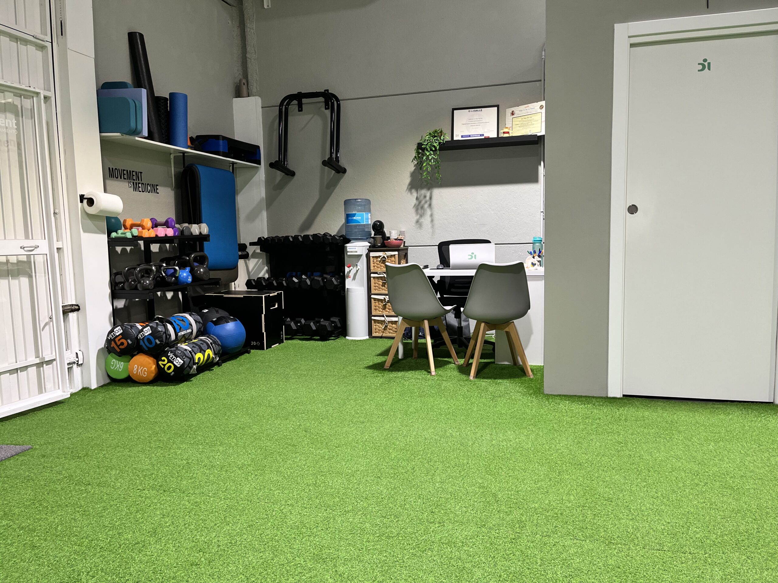 Entrada del centro de entrenamiento con mesa del CEO, fuente de agua, titulaciones del entrenador y material deportivo