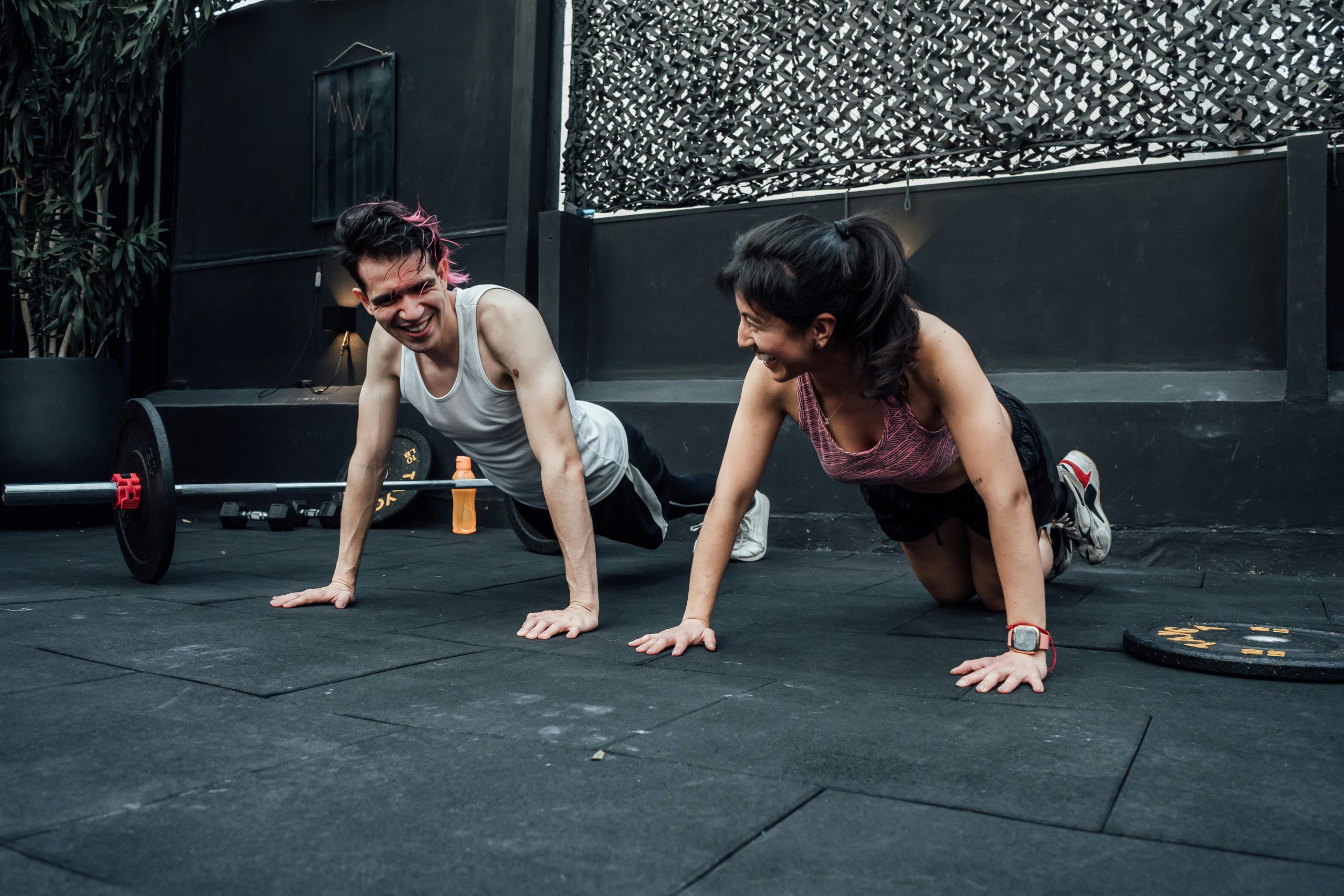 Hombre y mujer en posición de flexiones en el suelo listo para comenzar a realizar ejercicio